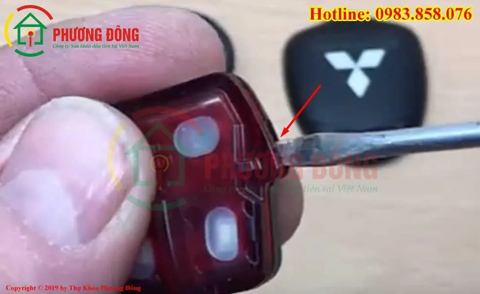 Dùng tuốc nơ vít cạy cụm bên trong ổ khóa để thay pin chìa khoá ô tô Mitsubishi