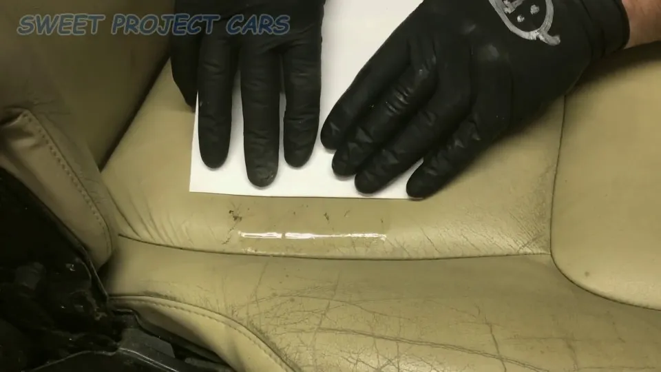 Quá trình chuyên gia sử dụng miếng bìa cứng để tán đều keo silicone trên bề mặt ghế da