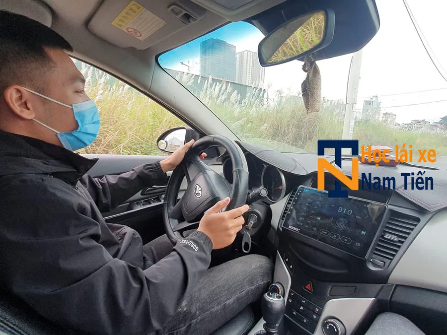 Hình ảnh giáo viên hướng dẫn học viên thực hành lái xe ngoài đường trường thực tế, tập xử lý tình huống giao thông