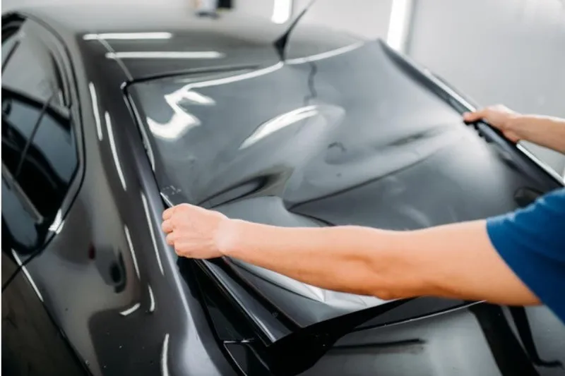 Tấm phim cách nhiệt ô tô được dán lên cửa kính, minh họa cơ chế phản xạ ánh sáng mặt trời