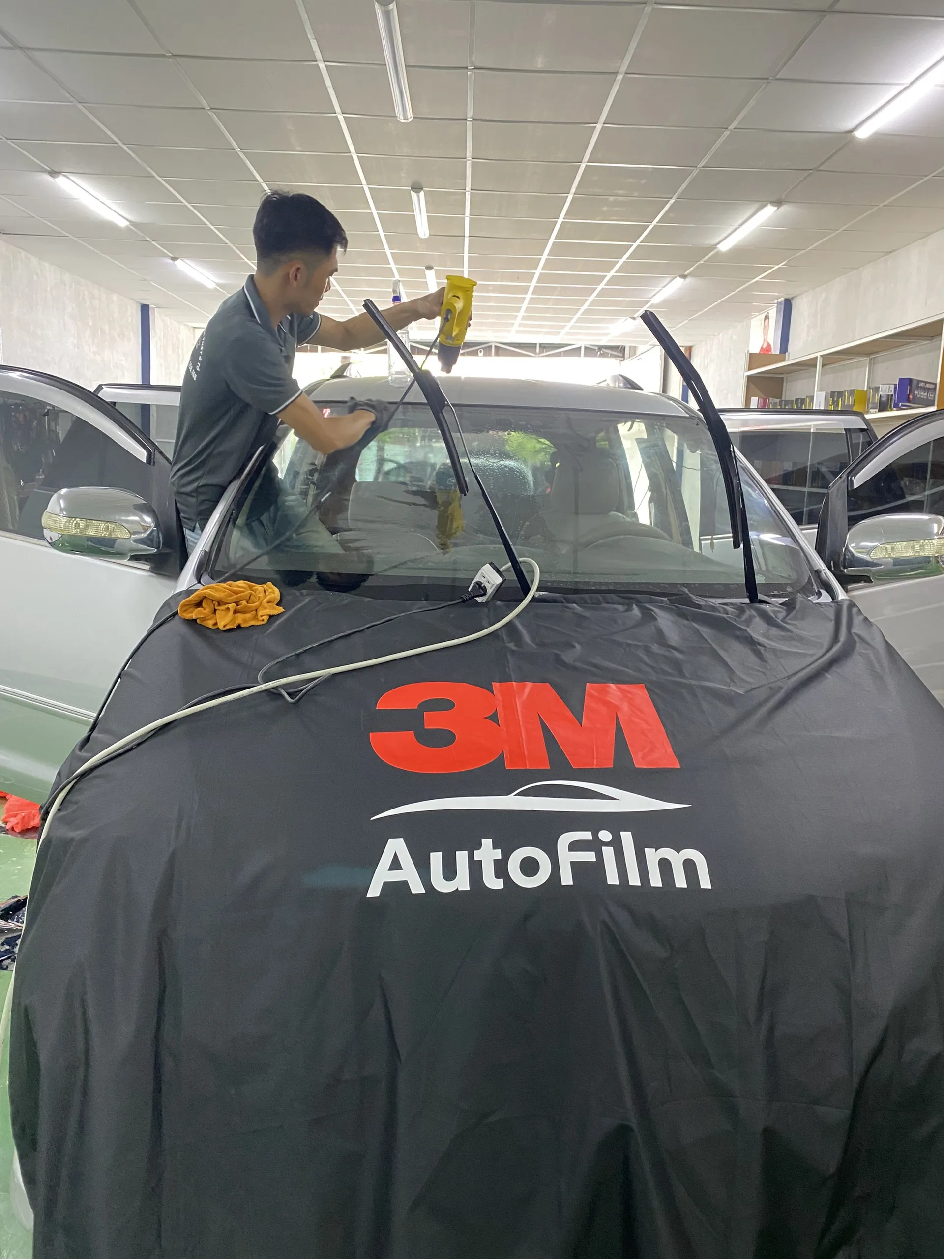 Thực hiện việc sấy nóng film để ôm theo độ cong của kính