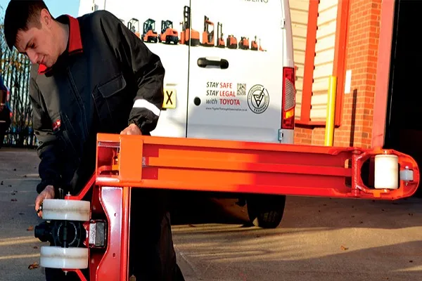 Kỹ thuật viên đang kiểm tra bơm thủy lực xe nâng tay tại xưởng