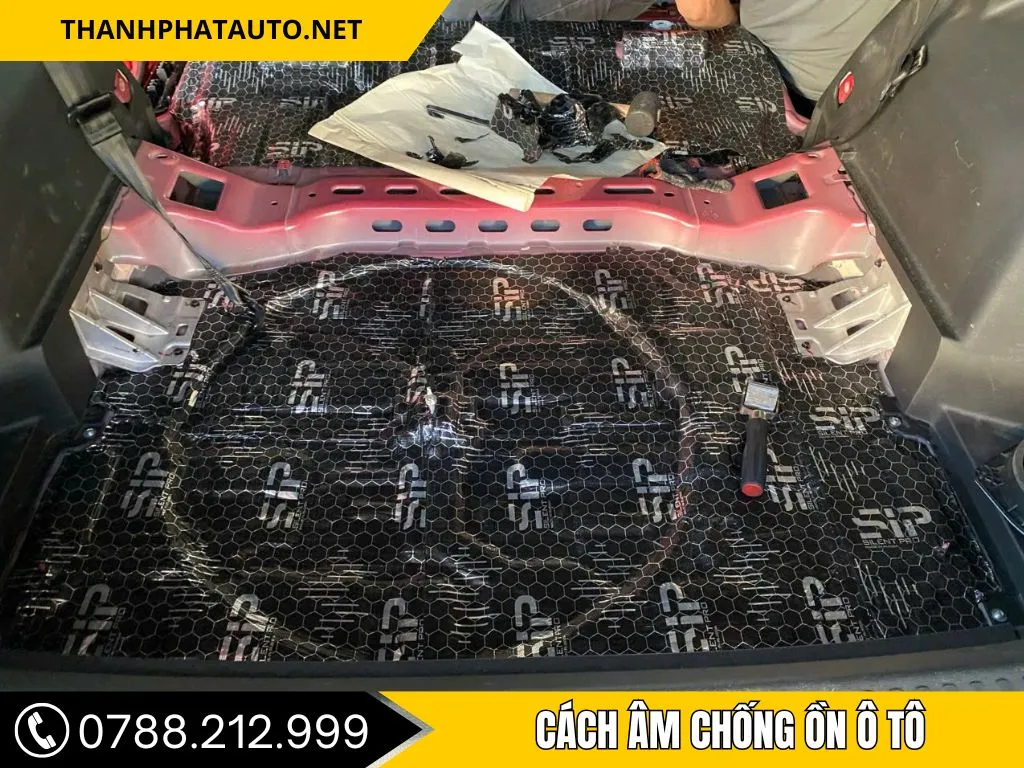 Kỹ thuật viên đang thi công cách âm chống ồn ô tô chuyên nghiệp cho sàn xe