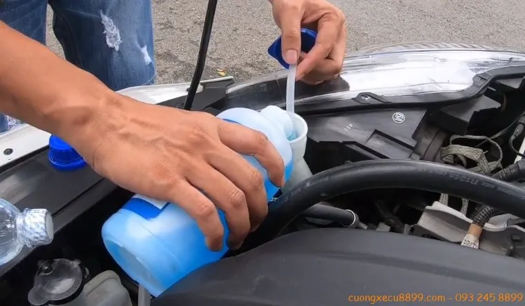 Thực hiện châm nước rửa kính xe ô tô bằng phễu sạch sẽ
