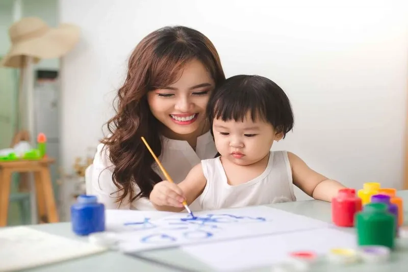 Bé trai đang tô màu chiếc ô tô đơn giản trên bàn học