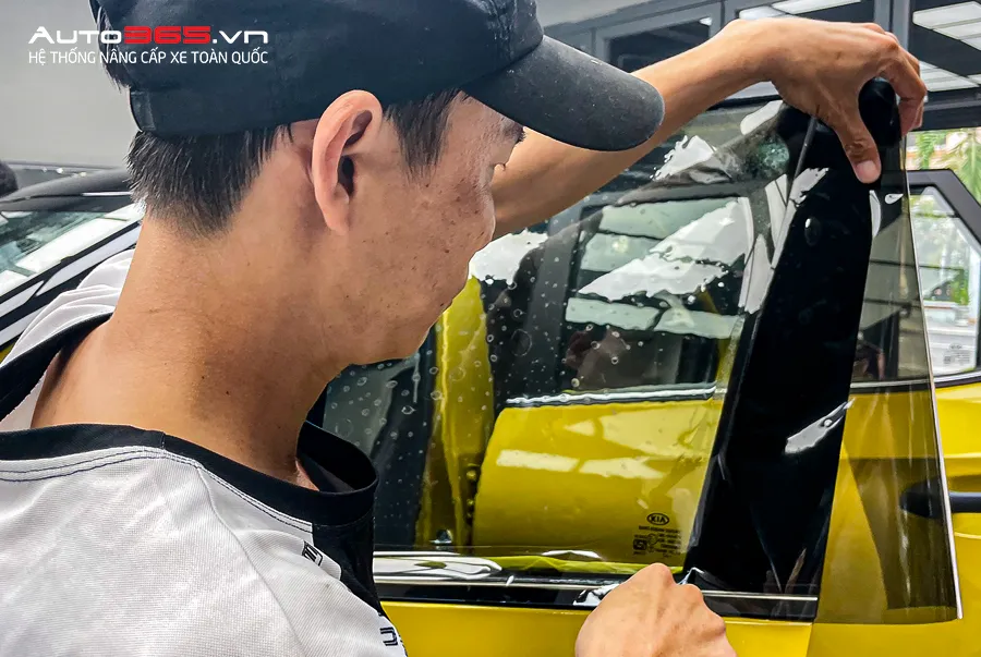 Kỹ thuật viên đang thi công dán phim cách nhiệt 3M chính hãng cho ô tô tại khu vực chuyên dụng