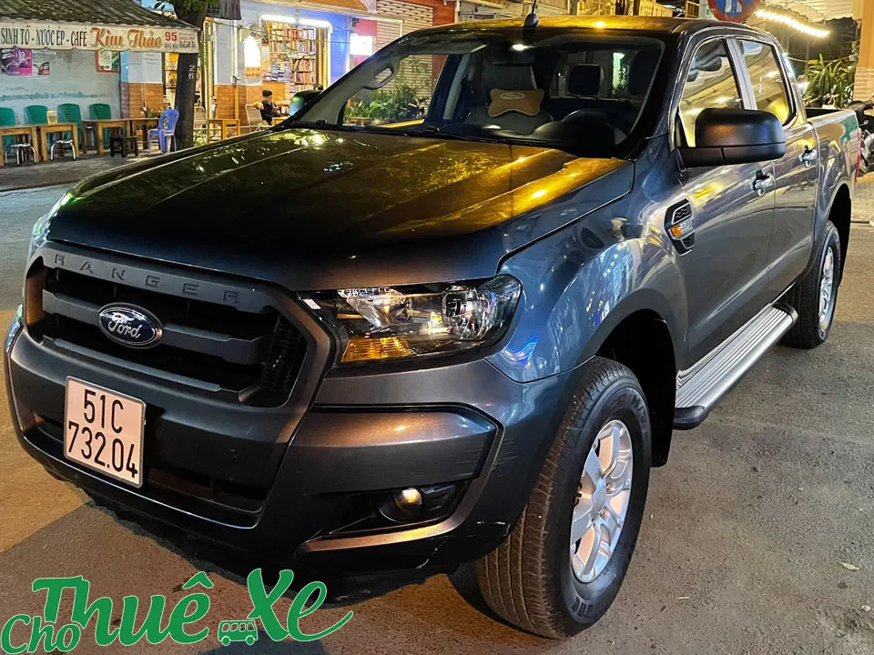 Ford Ranger màu đỏ đang đậu trên bãi cỏ dưới ánh nắng