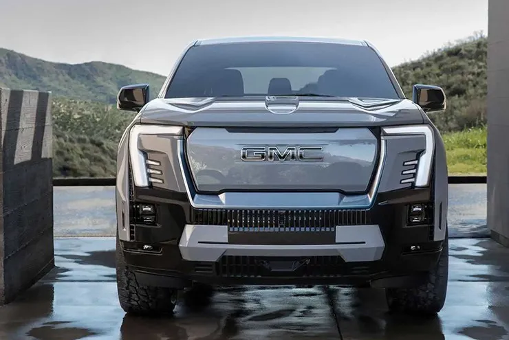 GMC Sierra EV Denali Edition 1 màu trắng bạc chụp cận cảnh đèn pha và lưới tản nhiệt
