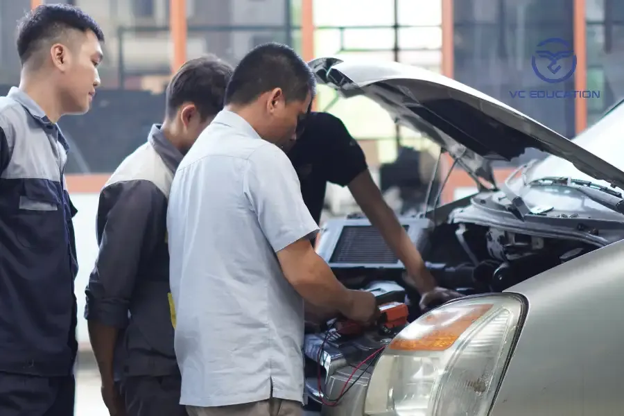 Kỹ thuật viên đang kiểm tra hệ thống điều khiển điện tử trên xe trong trung tâm đào tạo VCE