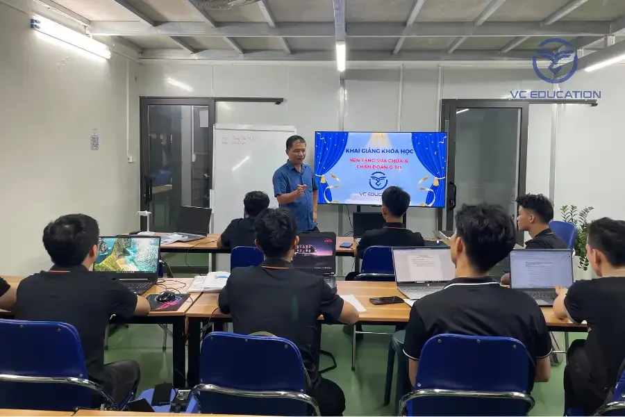 Kỹ thuật viên đang thực hành chẩn đoán lỗi điện tử trên ô tô bằng máy chẩn đoán chuyên dụng