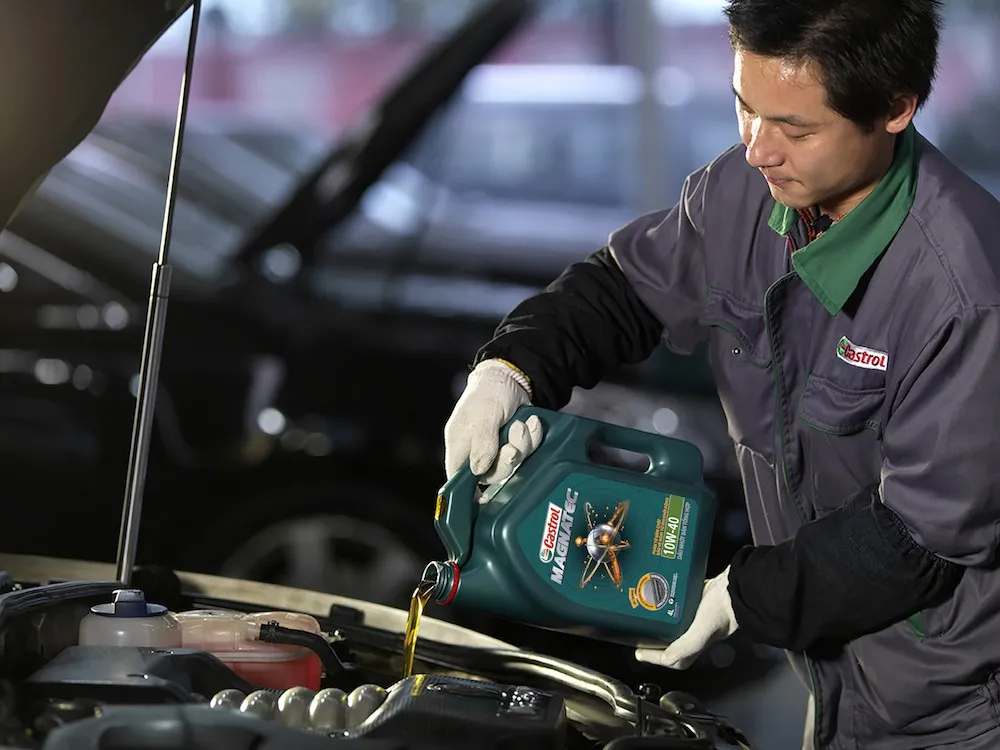 Châm dầu mới qua phễu vào động cơ xe tải theo hướng dẫn