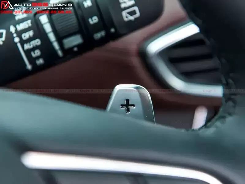 Mô tả cụ thể nội dung hình bằng tiếng Việt, minh họa lẫy chuyển số gắn trên vô lăng xe Ford Ranger với dấu cộng và trừ