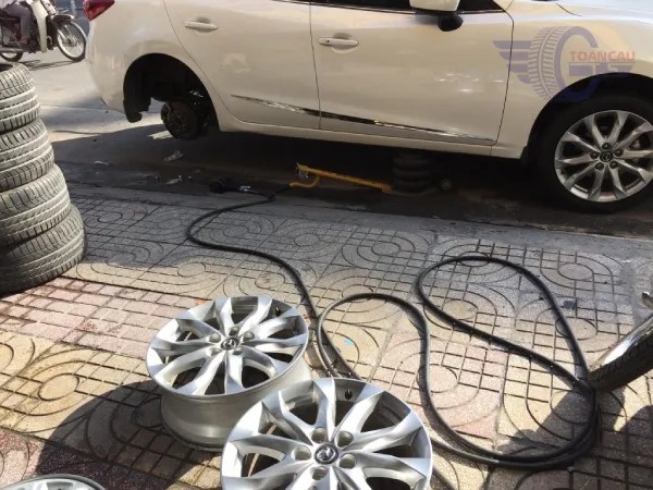 Hình ảnh xe ô tô đang được thay mâm mới tại xưởng, lưu ý khi thay đổi mâm xe