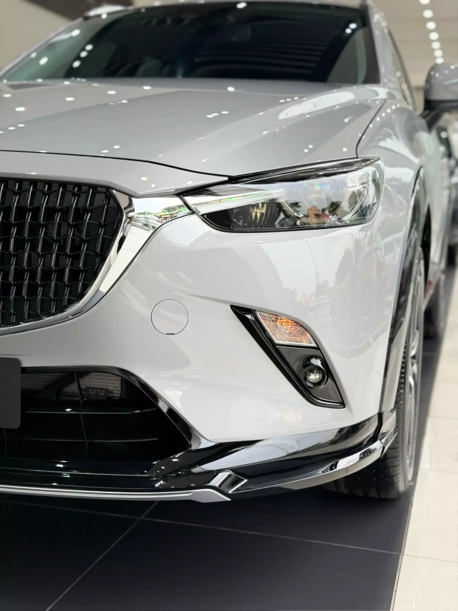 Đèn chiếu sáng trước xe Mazda CX-3 màu xám tại đại lý.