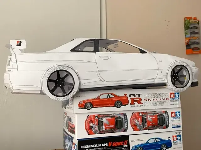 Cận cảnh các vật liệu cơ bản bao gồm hộp bìa carton, kéo, băng dính, và bút chì cần thiết để bắt đầu làm mô hình ô tô bằng giấy