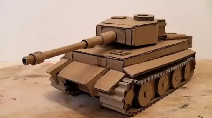 Khung thân xe cơ bản được dán cố định bằng băng dính, cho thấy cấu trúc hình hộp đang được tạo hình thành mô hình xe ô tô bằng giấy