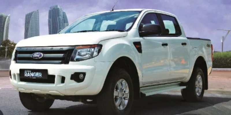 Kỹ thuật viên đang kiểm tra khung gầm và động cơ xe bán tải cũ, kinh nghiệm mua xe bán tải cũ dưới 350 triệu