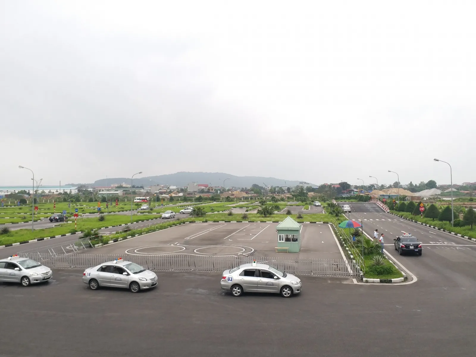 Giáo viên hướng dẫn học viên thực hành trên sân tập lái xe ô tô