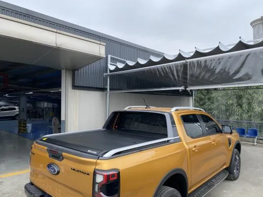 Nắp thùng cuộn điện được mở một phần trên Ford Ranger 2023 màu xanh