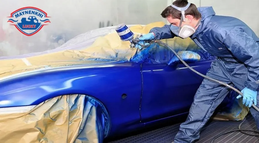 Thợ sơn đeo mặt nạ bảo hộ trong phòng sơn, tuân thủ an toàn lao động khi thực hiện quy trình sơn xe ô tô