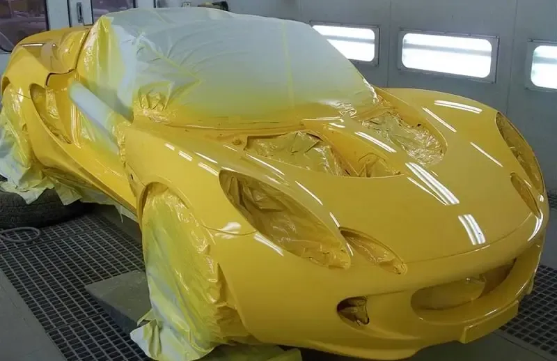 Kỹ thuật viên chuyên nghiệp đang pha màu sơn xe ô tô bằng máy đo màu điện tử