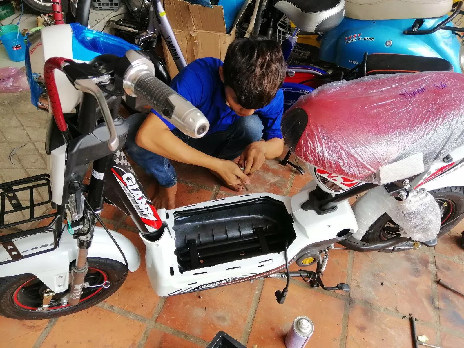 Kỹ thuật viên kiểm tra hệ thống dây điện và vi mạch điều khiển xe máy điện tại Đà Nẵng