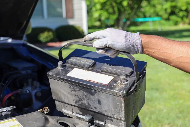 Tháo ắc quy ra khỏi xe sau khi đã ngắt các cực và tháo các chốt giữ