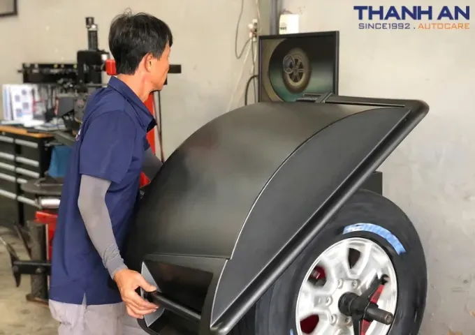 Kỹ thuật viên cân bằng động lốp xe ô tô sau khi thay lốp mới