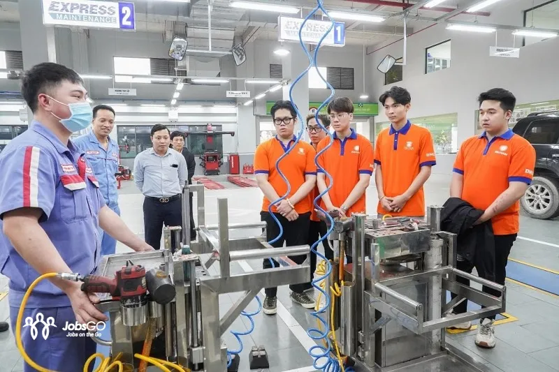 Thợ kỹ thuật đang sửa chữa và kiểm tra động cơ ô tô, minh họa tố chất cần thiết