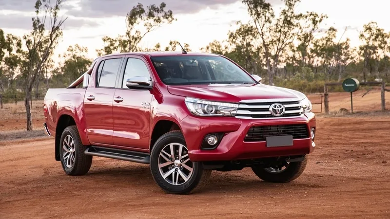 Toyota Hilux 2017 màu đỏ đang di chuyển trên đường đất, thể hiện khả năng vượt địa hình mạnh mẽ