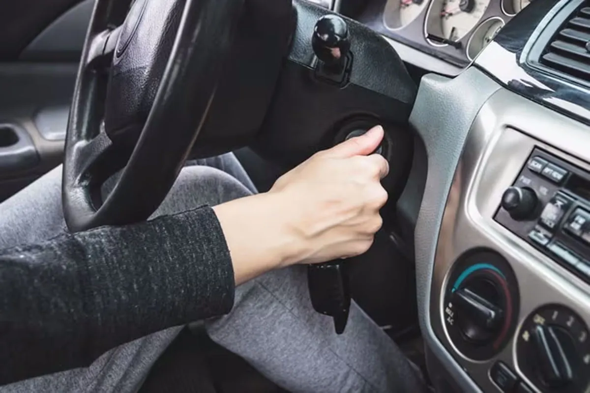 Người lái xe đang vặn chìa khóa để khởi động nhưng xe ô tô đề không nổ