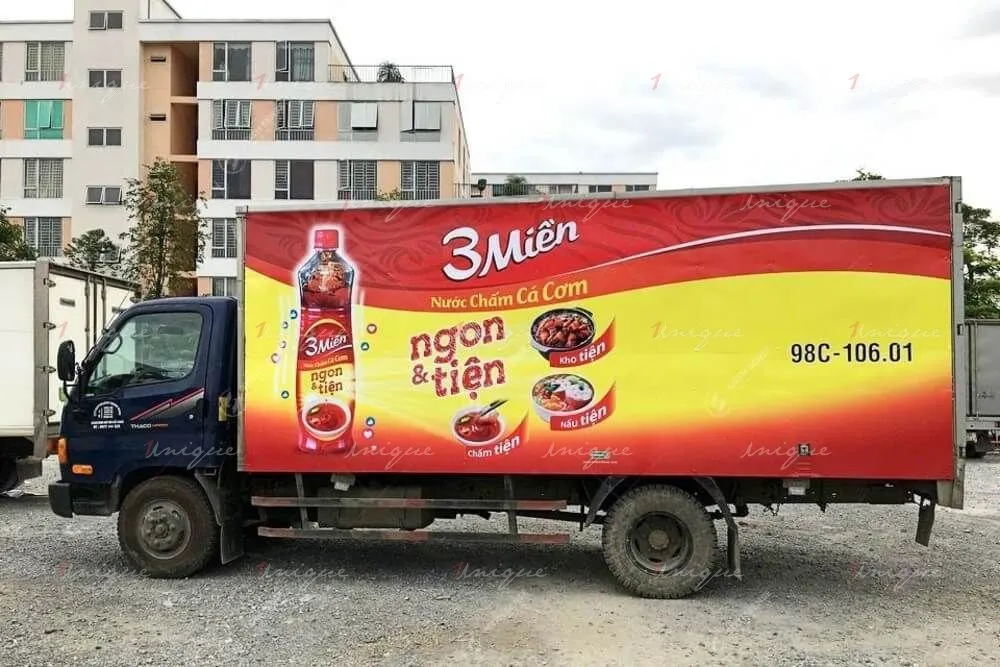 Hình ảnh xe tải và bán tải dán decal quảng cáo kín hai bên thùng xe đang di chuyển