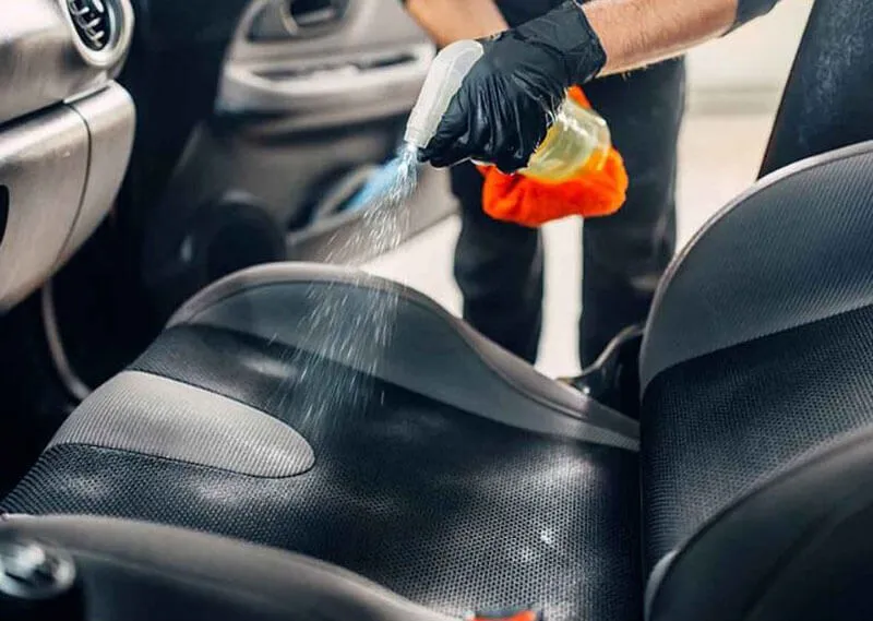 Xịt dung dịch vệ sinh lên bề mặt ghế nỉ