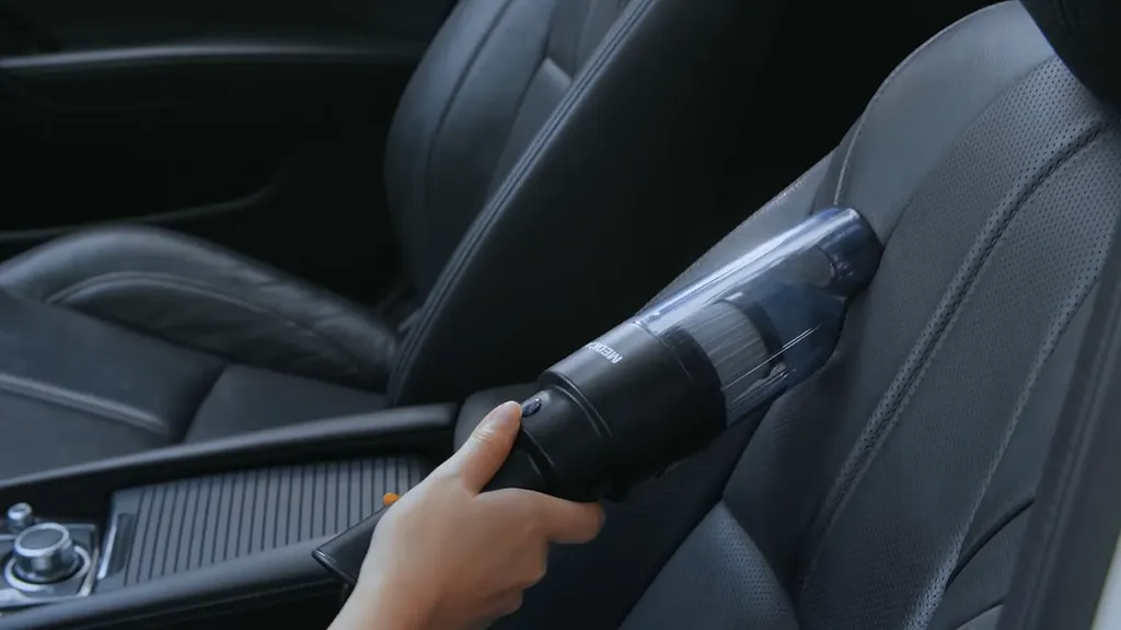 Chuyên gia đang sử dụng máy chà và dung dịch để làm sạch kỹ lưỡng bề mặt ghế da ô tô