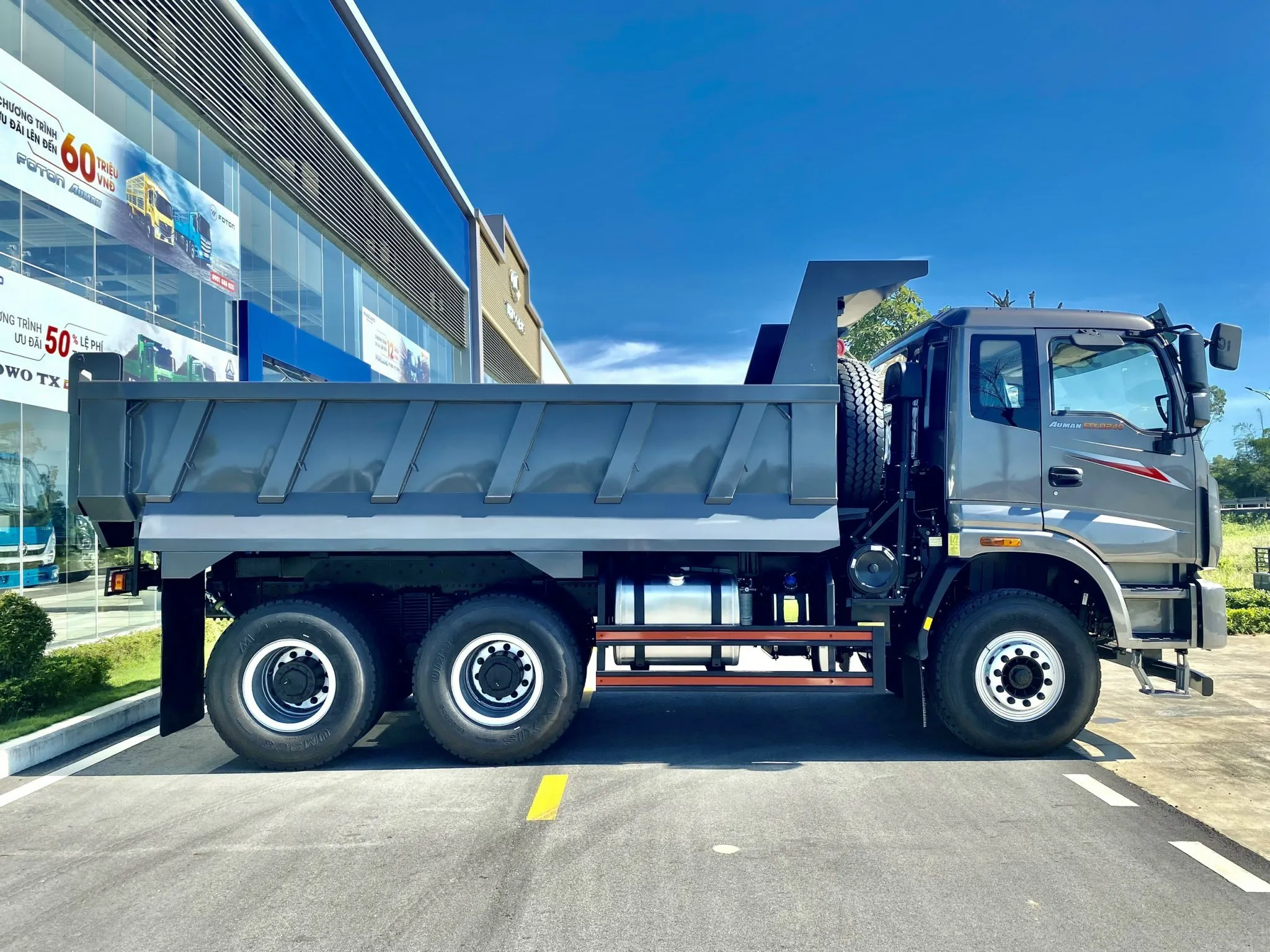 Cận cảnh xe ben Auman 3 chân đang nghiêng thùng ben, thể hiện cơ cấu ty ben hoạt động