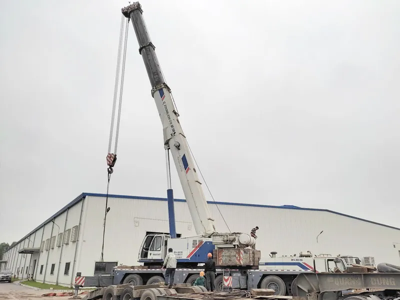 Xe cẩu đang thực hiện di dời máy móc thiết bị nặng vào nhà xưởng hiện đại