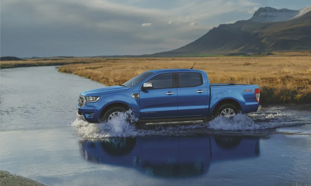 Xe bán tải đang chuyển động trên đoạn đường đất dốc, thể hiện khả năng bám đường của hệ thống 4x4