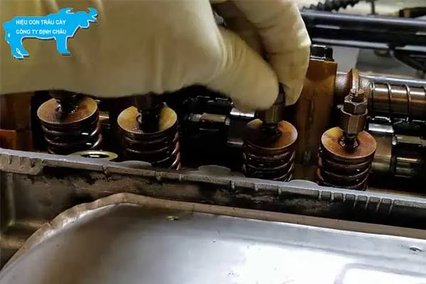 Kỹ thuật viên đang dùng thước căn lá (feeler gauge) để đo và kiểm tra khe hở xupap