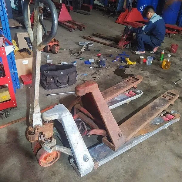 Kỹ thuật viên đang thay thế bơm thủy lực xe nâng tay