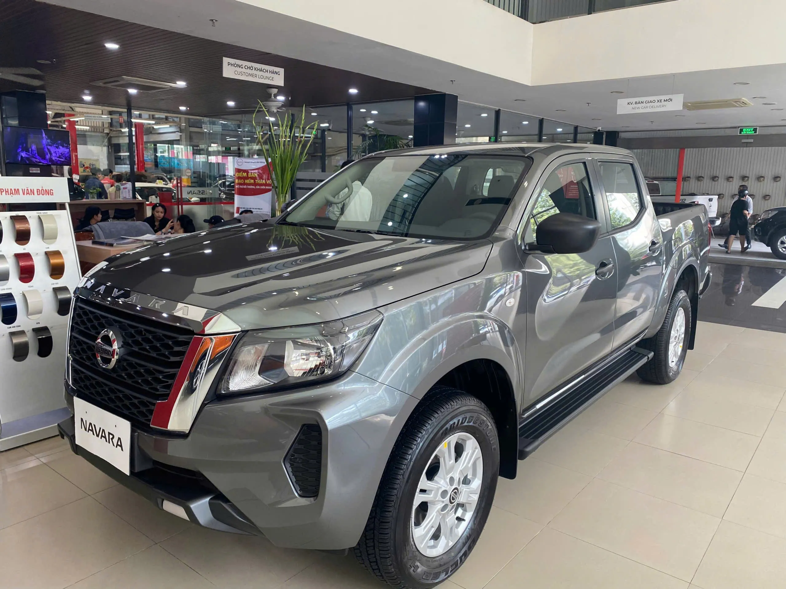 allintitle:xe bán tải navara EL 2WD màu trắng đang di chuyển trên đường phố